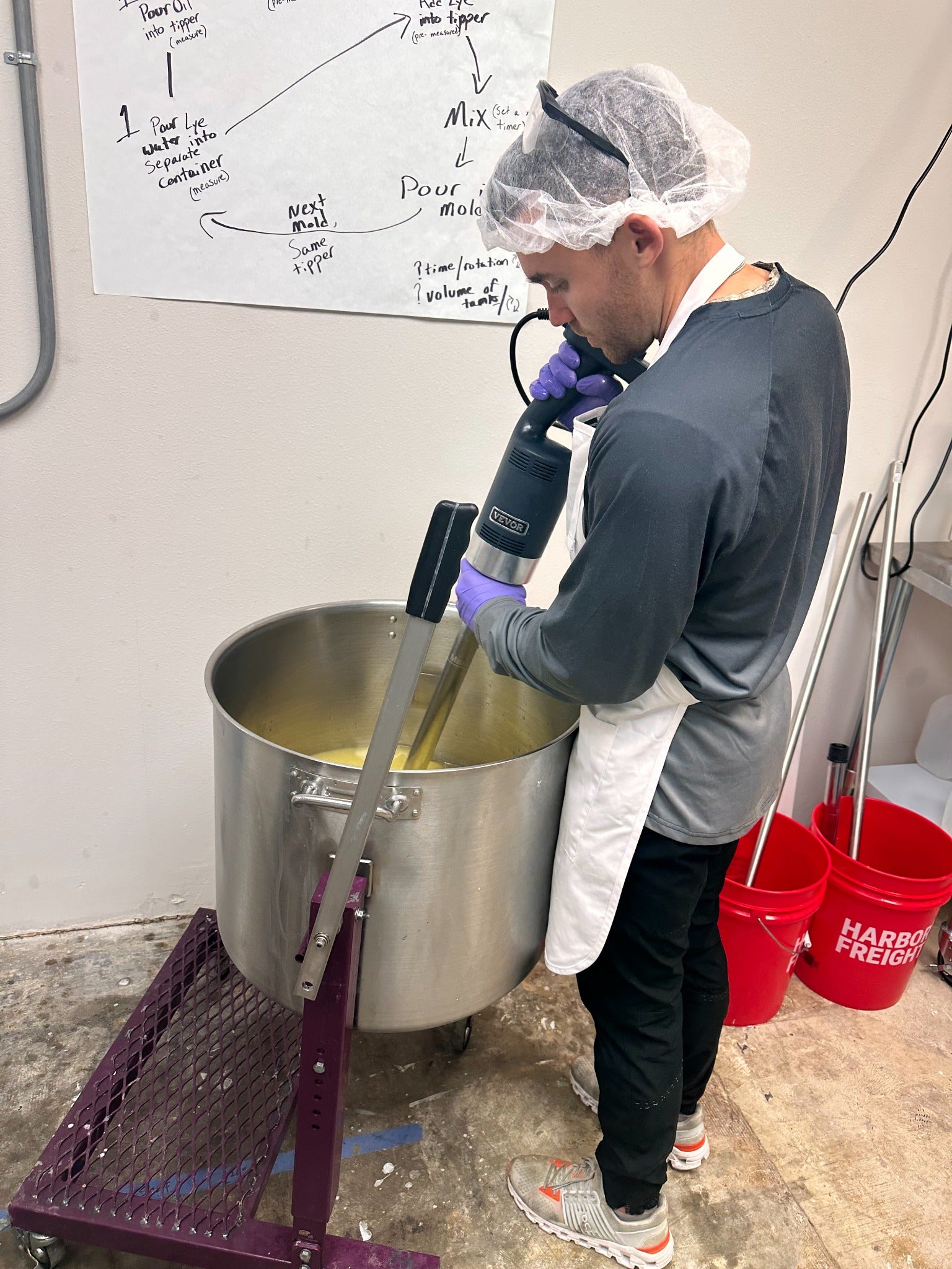 Production team member mixing a large soap batch